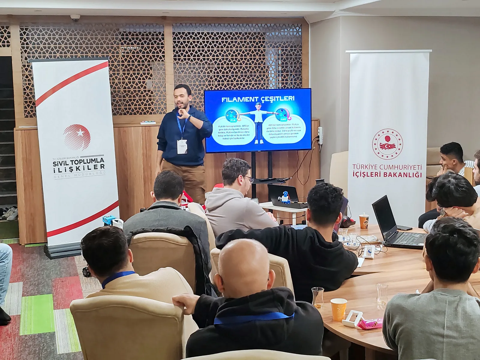 Eğitmen ekrandaki 3D yazıcı filamentleri sunumunu anlatıyor