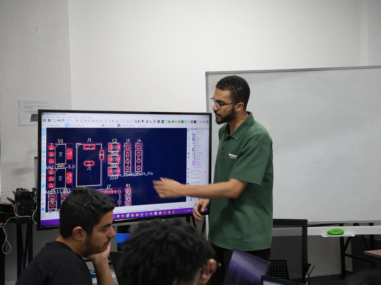 Eğitmen büyük ekranda bir PCB tasarımını gösteriyor