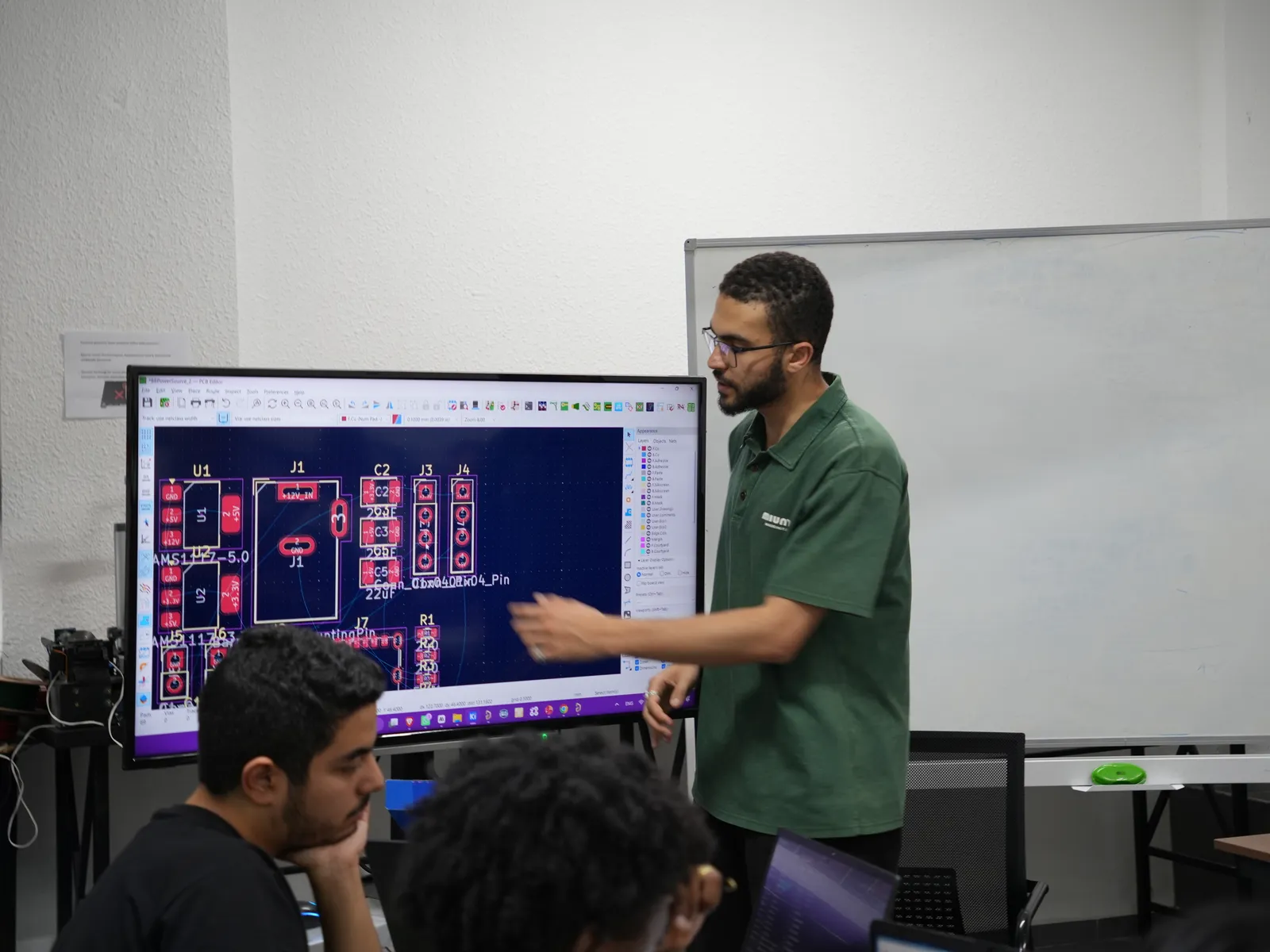 Eğitmen büyük ekranda bir PCB tasarımını gösteriyor